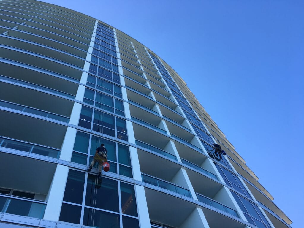 Window cleaners hanging from building